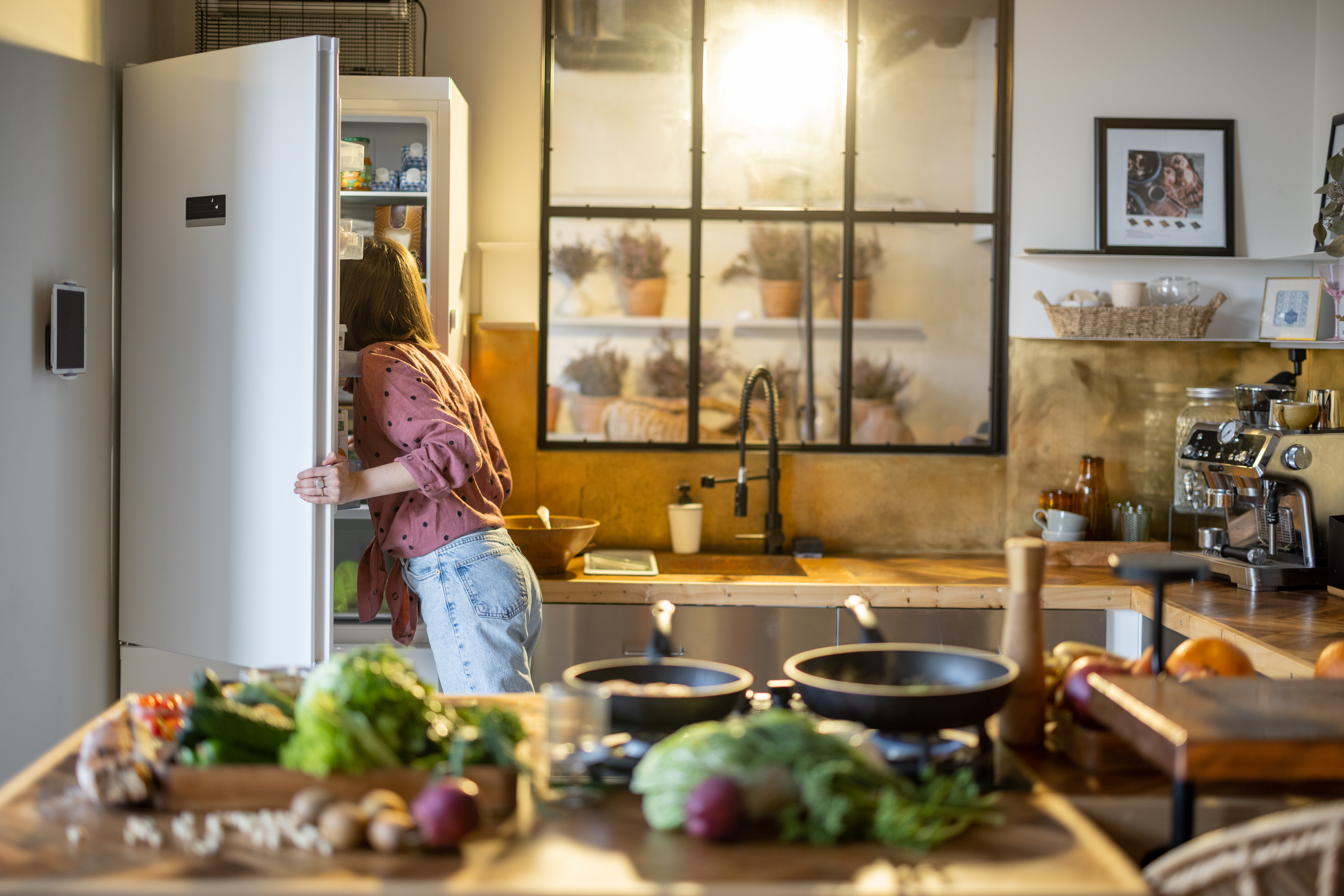 /media/n2iktx22/woman-reaches-into-refrigerator-in-bright-kitchen-2026-03-20-06-14-56-utc.jpg
